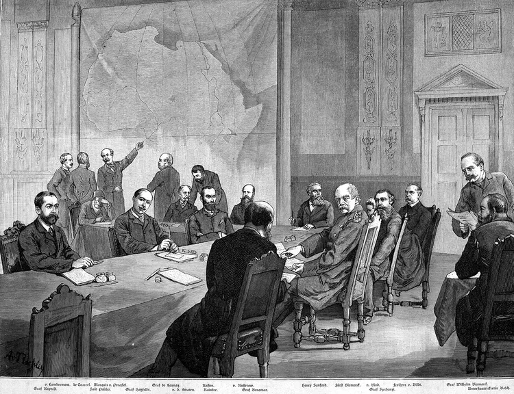 A black-and-white engraving of the Berlin Conference, 1884: European diplomats seated around a long table in a formal hall. A large map of Africa hangs on the wall behind them, one delegate gesturing toward it.