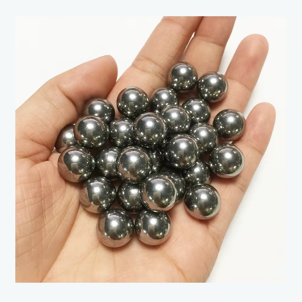 An open palm cupping roughly thirty polished steel pachinko balls, their mirror-bright surfaces catching the light.